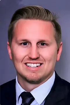 Smiling male dentist in suit and tie professional headshot